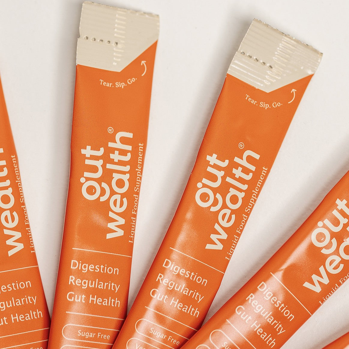 Gut Wealth liquid supplement sachets fanned out showing tear sip go design - postbiotic gut health sachets for digestion and regularity