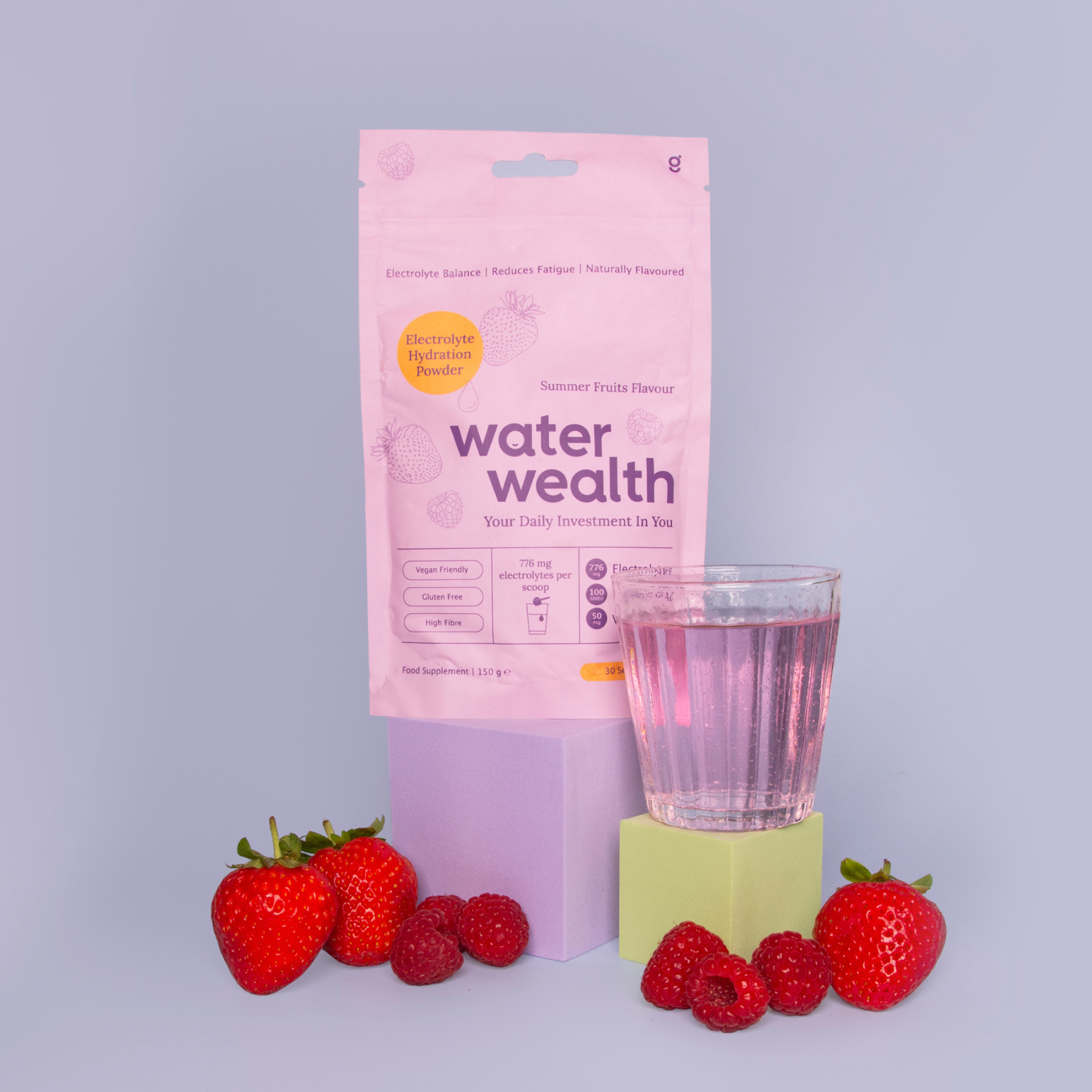 Water Wealth electrolyte powder sachet with mixed berry drink and fresh strawberries - gut health hydration supplement